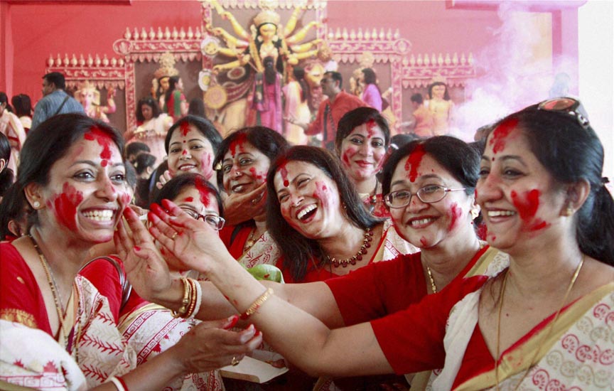 Gurgaon: Women participate in Sindur Khela (playing with vermilion powder) at a community puja pandal on the last day of Durga puja celebrations in Gurgaon on Saturday. PTI Photo(PTI10_4_2014_000046B)